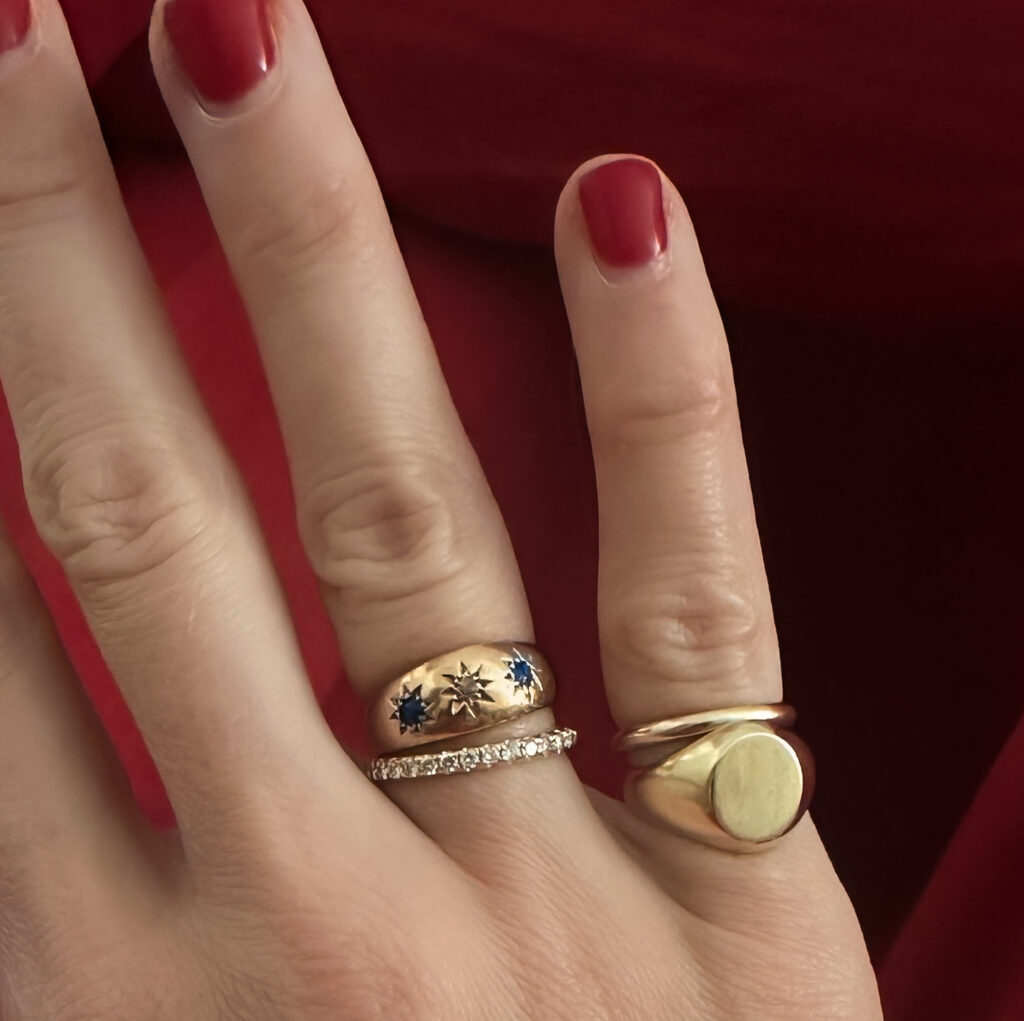 hand with ring stacks - kinn classic gold signet ring on the pinky. kinn jewelry 2026 discount code JESSI10